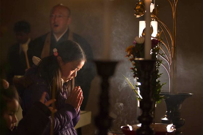 女孩雙手合十為往生者悼念